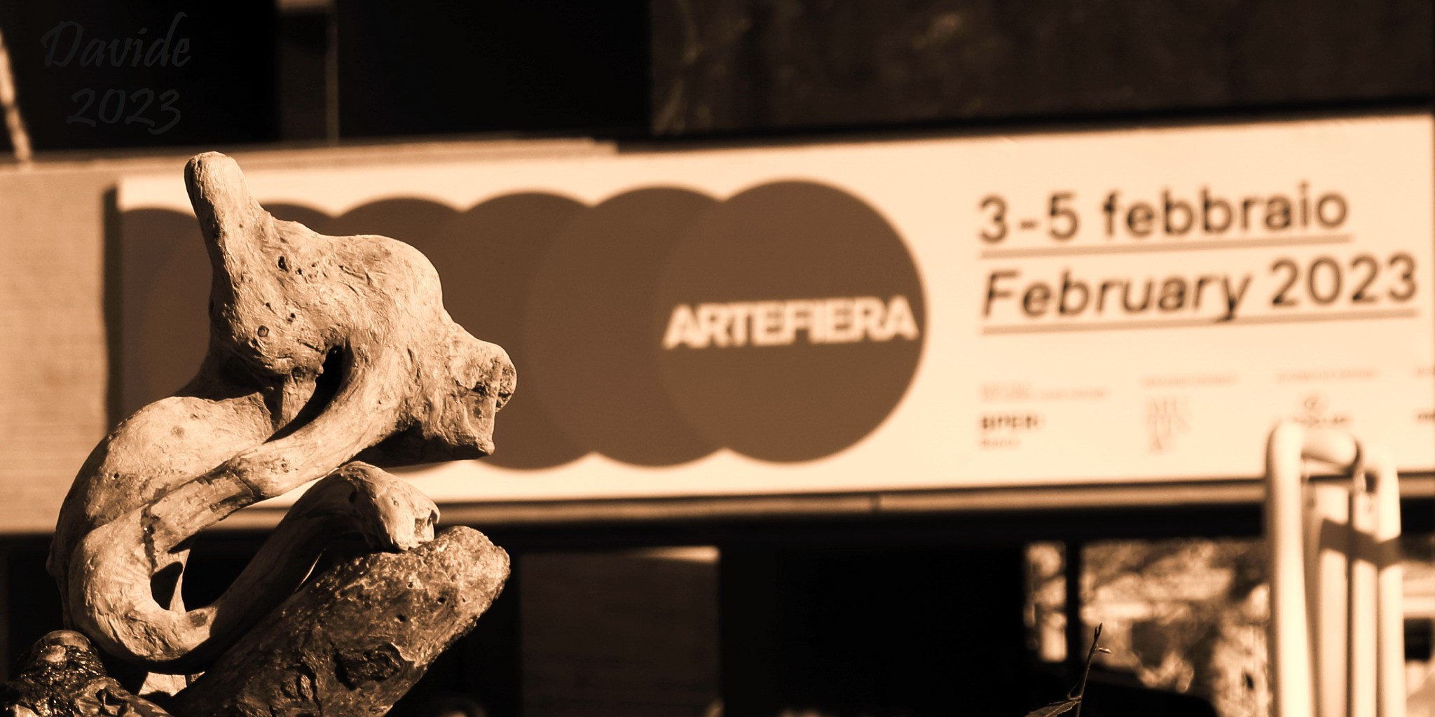Davide, “Forme sfuggenti #102 – Fiera di Bologna”, Bologna (Emilia-Romagna – Italia), febbraio 2023. Scultura di Erminio Tansini (“Senza titolo”, Anni ’90, legno delle Cinque Terre). © Davide Tansini